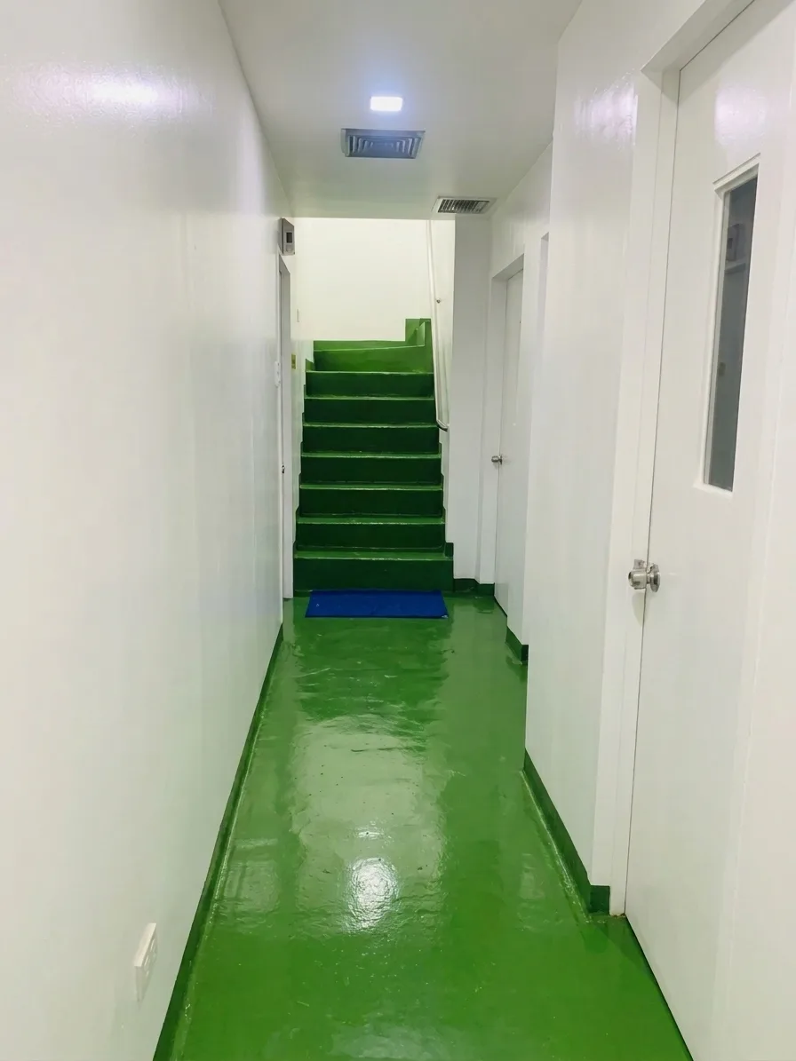 1st Floor Pathway: white-walled corridor with doors, a green floor, and green stairs at the far end.